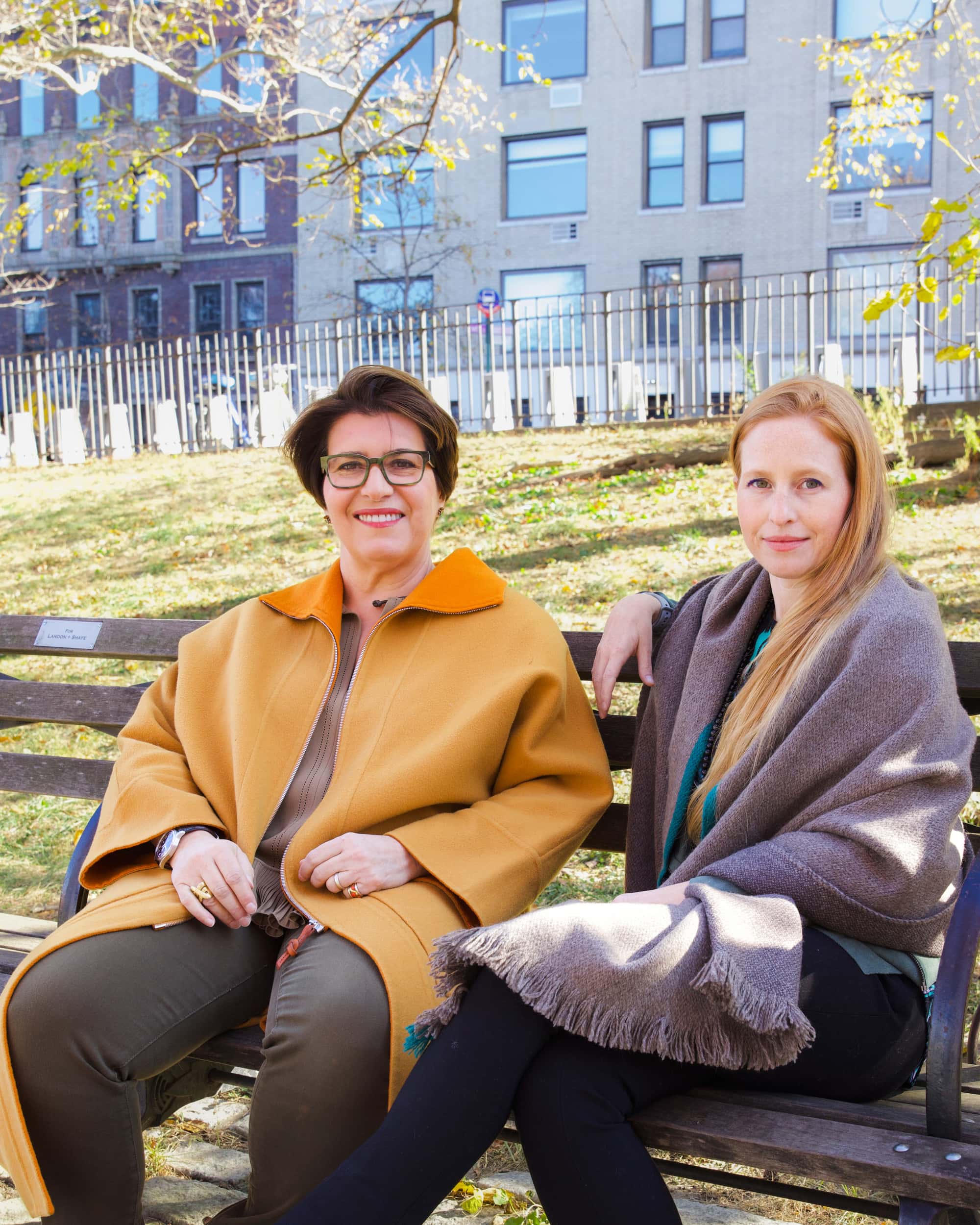 Molly Flanagan and Véronique Bogliolo Friedman sitting on a bench in a park